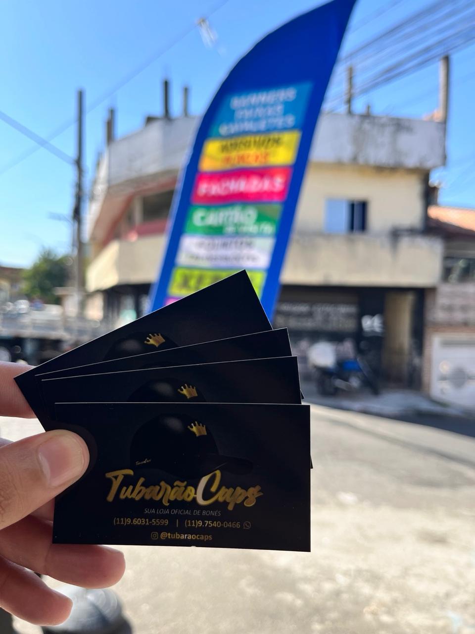 Cartões de visita com material de comunicação visual ao fundo