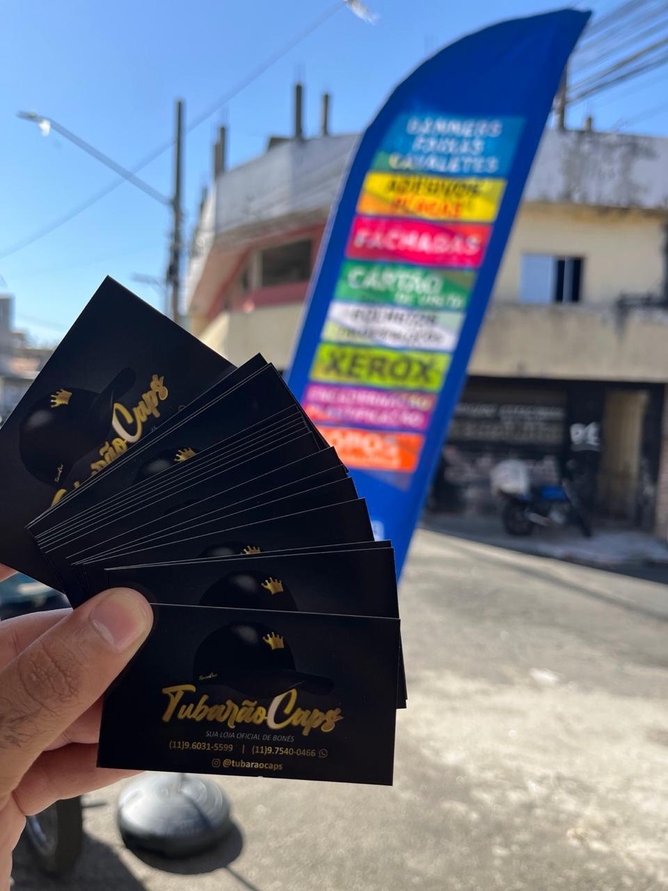 Cartões profissionais fotografados junto a comunicação visual externa